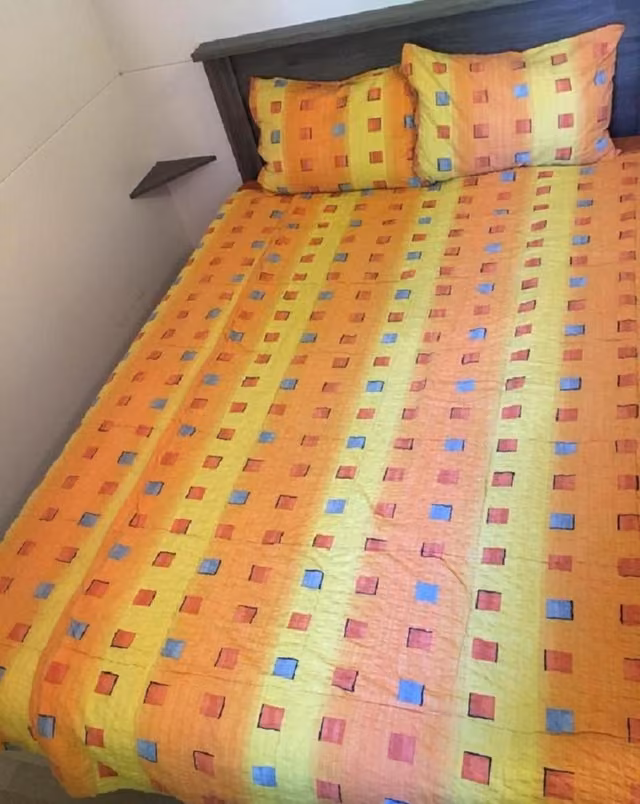 Camera matrimoniale con letto e cuscini in un appartamento del villaggio